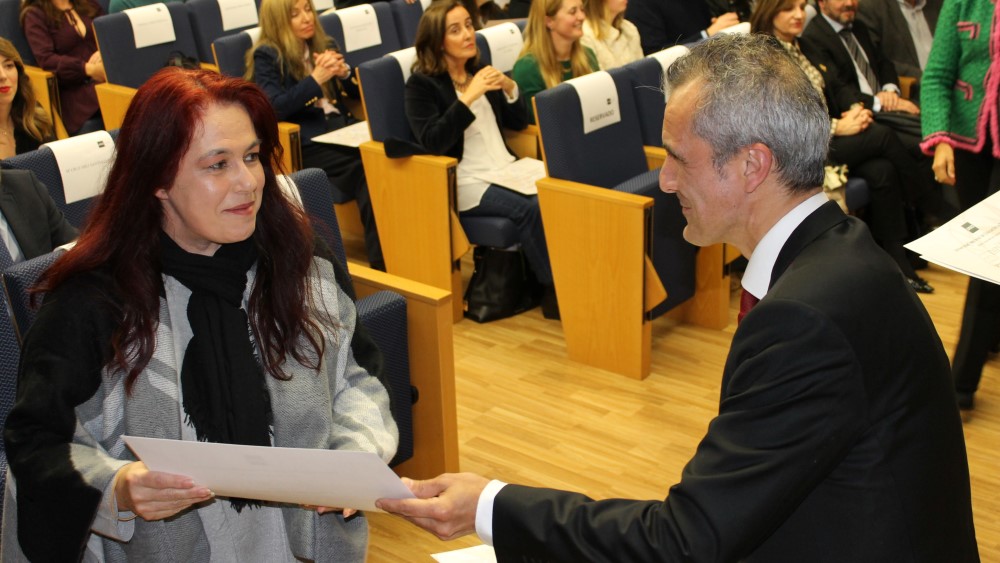 Alumna egresada recibe su diploma de manos del director de UNED Asturias.